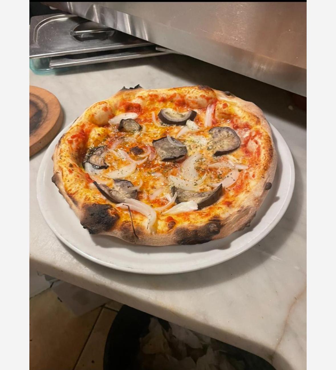 Italienische Pizza mit Pilzen frisch zubereitet im Ackerloch Grillschopf